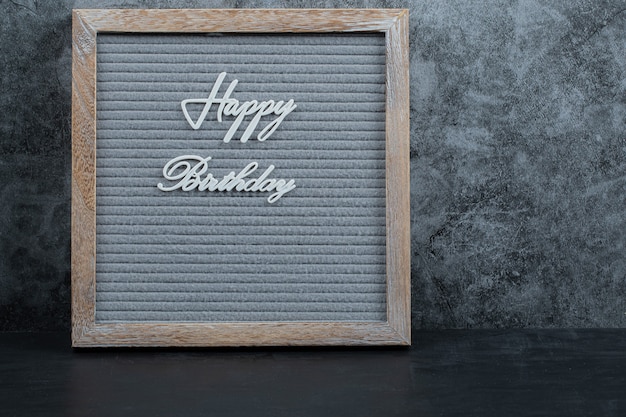 Free Photo happy birthday phrase embedded on the grey tissue