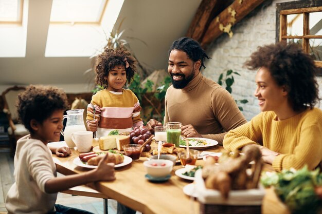 Happy black family enjoying in meal at dining table at home