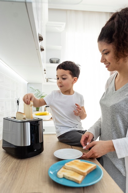 Free photo happy black kid helping his mom with breakfast