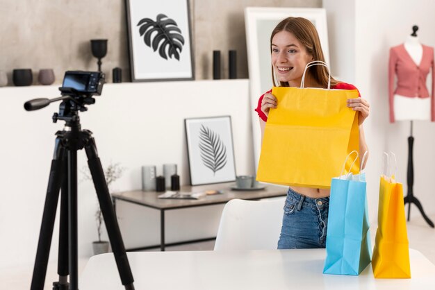 Happy blogger holding yellow shopping bag