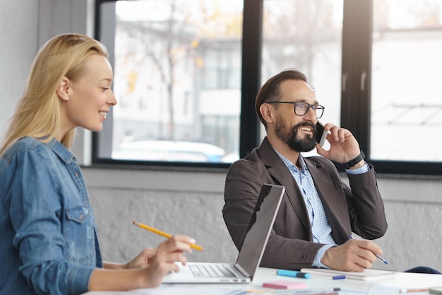 Free Photo happy blonde female manager has conversation with male colleague