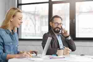 Free photo happy blonde female manager has conversation with male colleague