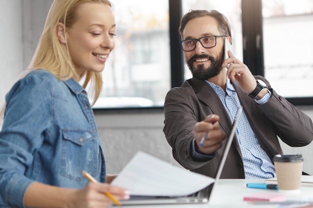 Free Photo happy blonde female manager has conversation with male colleague