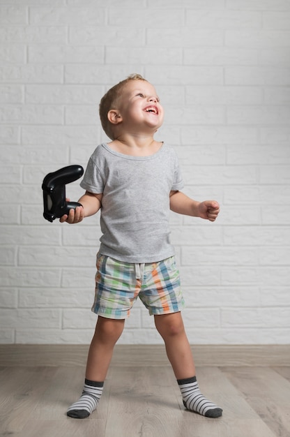 Happy boy playing with joystick at home