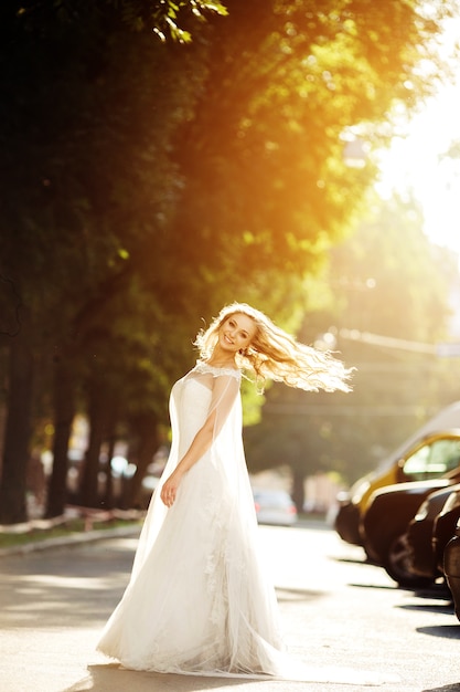 Happy bride posing with her white wedding dress