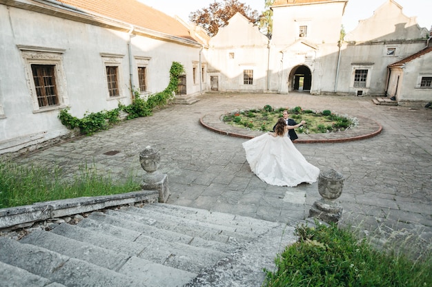 Happy brides dance near the castle