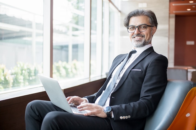 Free Photo happy business leader using tablet in lobby