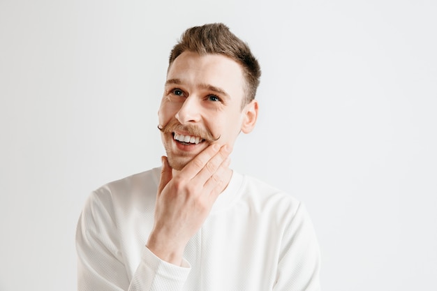 Happy business man standing, smiling isolated on gray studio background. Beautiful male half-length portrait. Young satisfy man. Human emotions, facial expression concept.