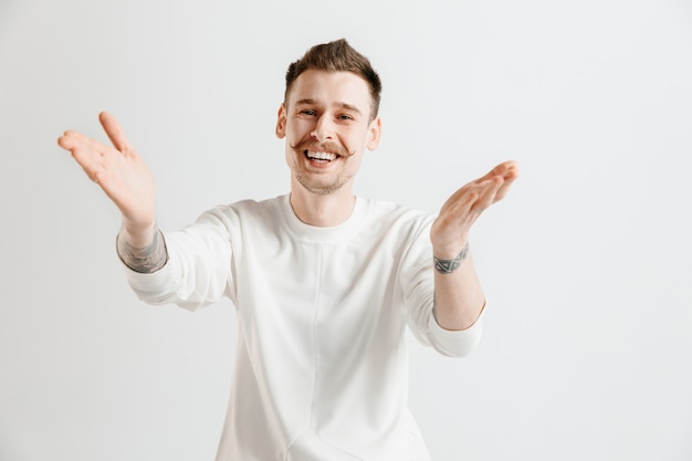 Happy business man standing, smiling isolated on gray studio background. Beautiful male half-length portrait. Young satisfy man. Human emotions, facial expression concept.