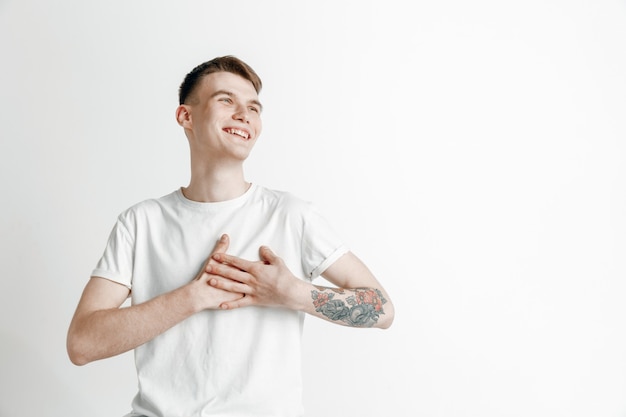 Happy business man standing, smiling isolated on gray studio background. Beautiful male half-length portrait. Young satisfy man. Human emotions, facial expression concept.