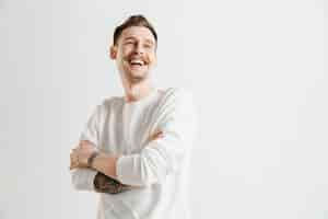 Free photo happy business man standing, smiling isolated on gray studio background. beautiful male half-length portrait. young satisfy man. human emotions, facial expression concept.