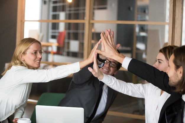 Free photo happy business team giving high-five together promising engagement and loyalty