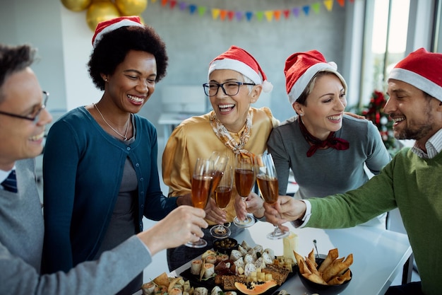 Free photo happy business team toasting with champagne on christmas party in the office