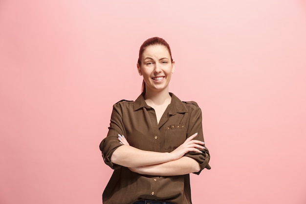 Free photo the happy business woman standing and smiling against pink wall.