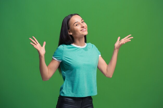 Happy business woman standing and smiling isolated on green studio background. Beautiful female half-length portrait. Young emotional woman. The human emotions, facial expression concept. Front view.