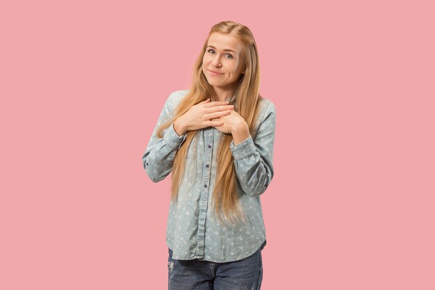 Happy business woman standing and smiling isolated on pink studio background. Beautiful female half-length portrait. Young emotional woman. The human emotions, facial expression concept. Front view.