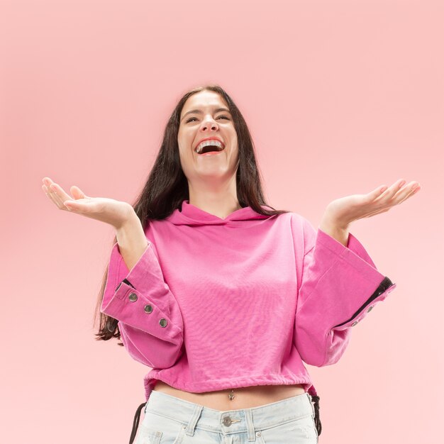 Happy business woman standing and smiling isolated on pink studio background. Beautiful female half-length portrait. Young emotional woman. The human emotions, facial expression concept