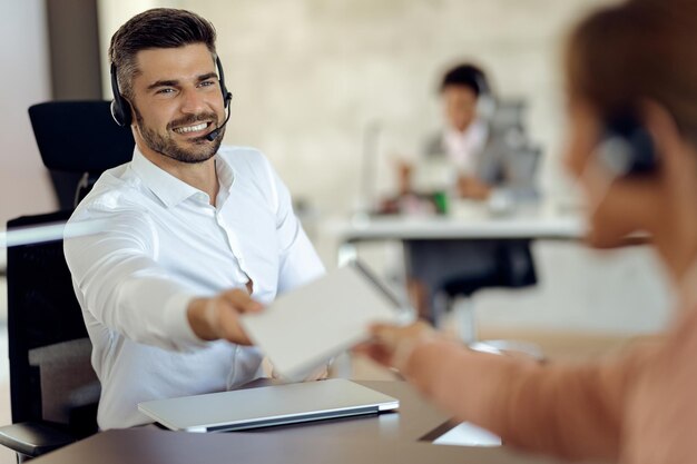 Happy businessman cooperating with his colleague while working in the office