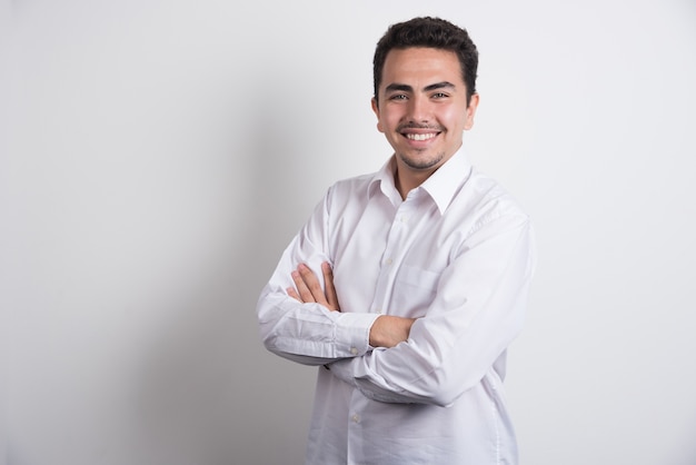 Happy businessman crossing arms on white background.