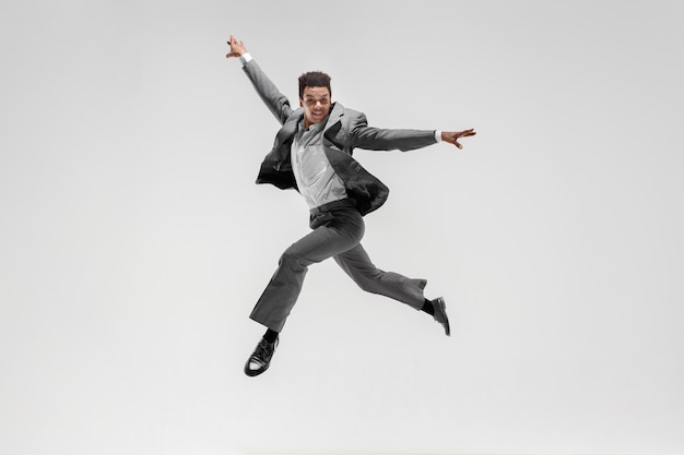 Free Photo happy businessman dancing in motion isolated on white studio background. flexibility and grace in business. human emotions concept. office, success, professional, happiness, expression concepts