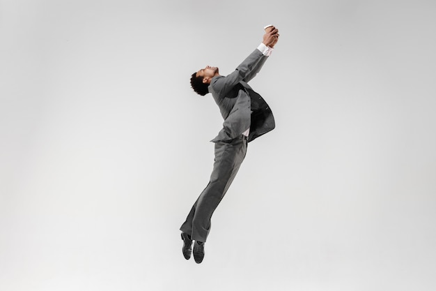 Free Photo happy businessman dancing in motion isolated on white studio background. flexibility and grace in business. human emotions concept. office, success, professional, happiness, expression concepts