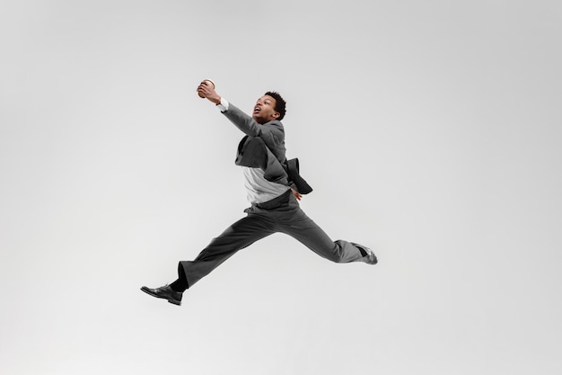 Happy businessman dancing in motion isolated on white studio background. Flexibility and grace in business. Human emotions concept. Office, success, professional, happiness, expression concepts