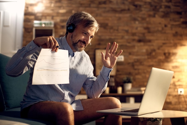 Free photo happy businessman having conference call over laptop from home