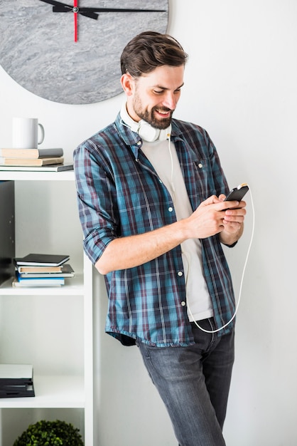 Happy businessman listening to music on mobile phone