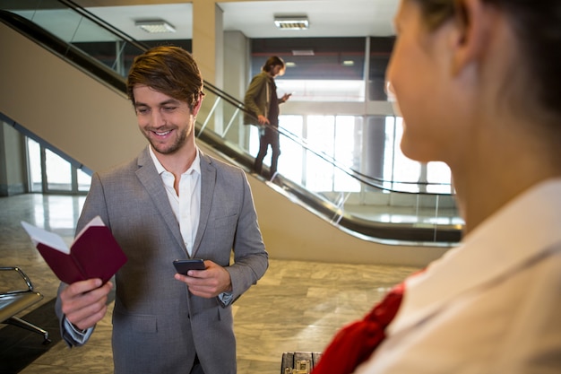 Happy businessman looking at his passport while standing