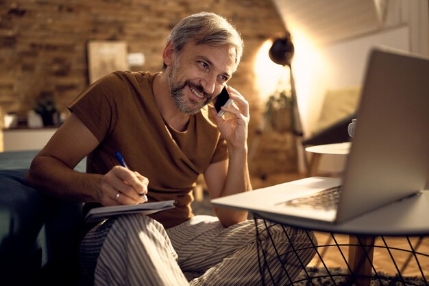 Happy businessman in pajamas working late in the evening at home