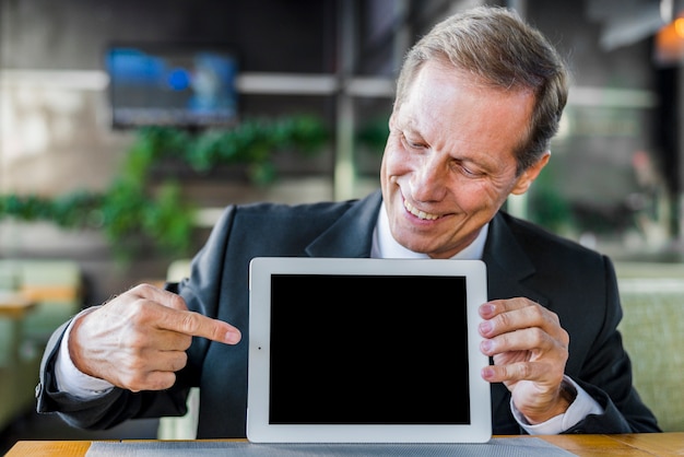 Free photo happy businessman pointing at blank screen of digital tablet