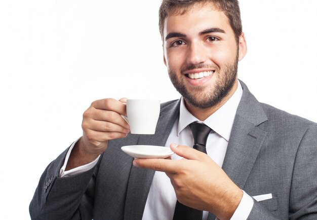 Happy businessman posing with a cup and a saucer