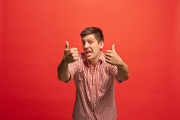 Free photo happy businessman, sign ok, smiling, isolated on trendy red studio background. beautiful male half-length portrait.