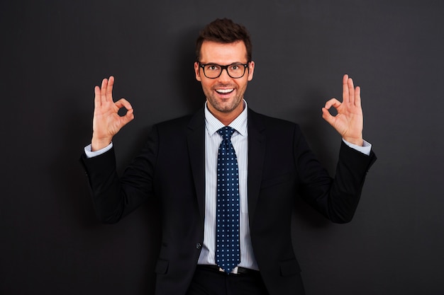 Free photo happy businessman wearing glasses showing ok sign