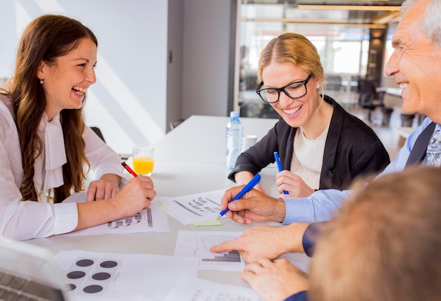 Free photo happy businesspeople discussing a financial plan in the meeting