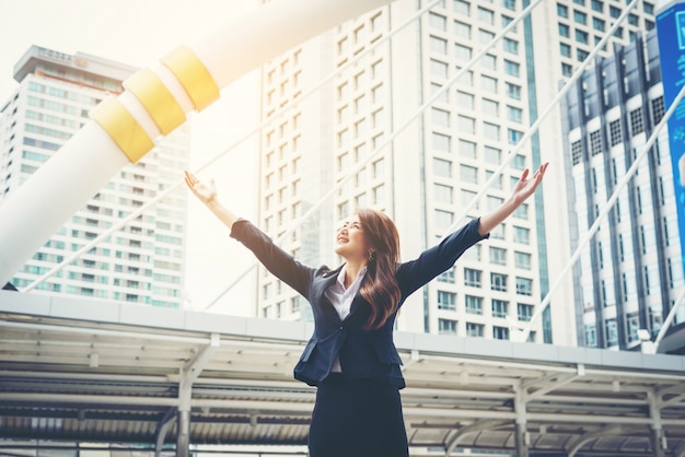 Free photo happy businesswoman exults pumping fists ecstatic celebrates success outdoor.