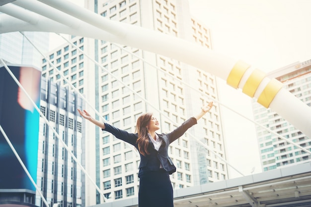 happy businesswoman exults pumping fists ecstatic celebrates success outdoor.