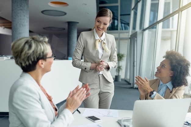 Free photo happy businesswoman getting applause after successful presentation on a meeting