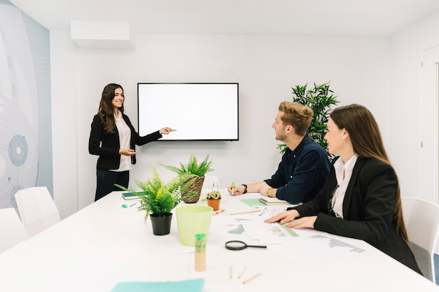 Happy businesswoman giving presentation to her partners in business meeting