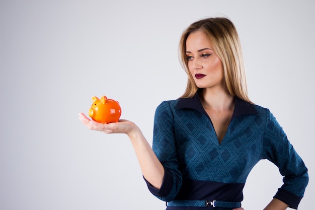 Happy businesswoman holding piggy bank against white background. Safings concept holding piggy bank top view.