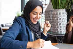 Free photo happy businesswoman taking notes