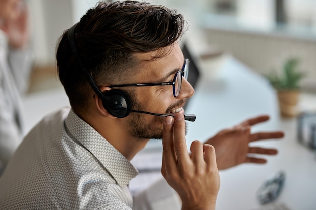 Free Photo happy call center agent wearing headset while talking with clients and working in the office