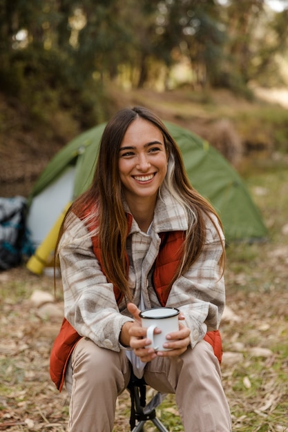 Happy camping girl in the forest smiling