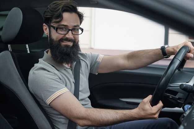 Happy car driver with fastened seat belt