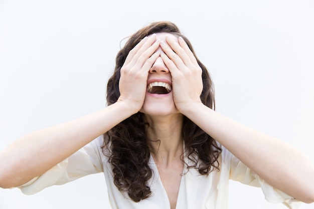 Happy carefree woman covering face with hands