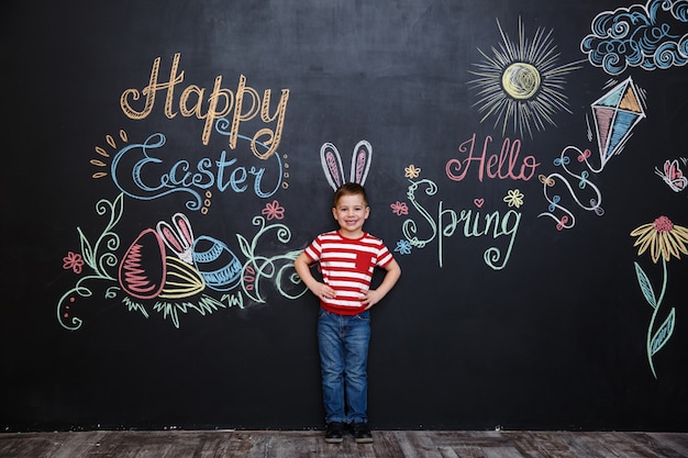 Free photo happy cheerful little boy wearing bunny ears and celebrating easter