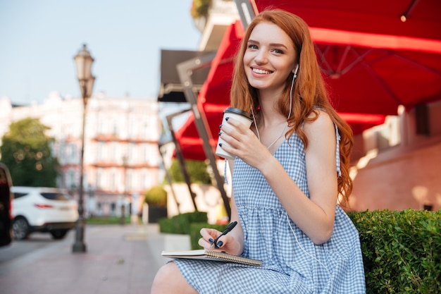 Happy cheerful redhead girl in earphones