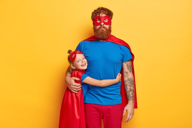 Free photo happy childhood and fatherhood concept. smiling small redhead female kid embraces with love father