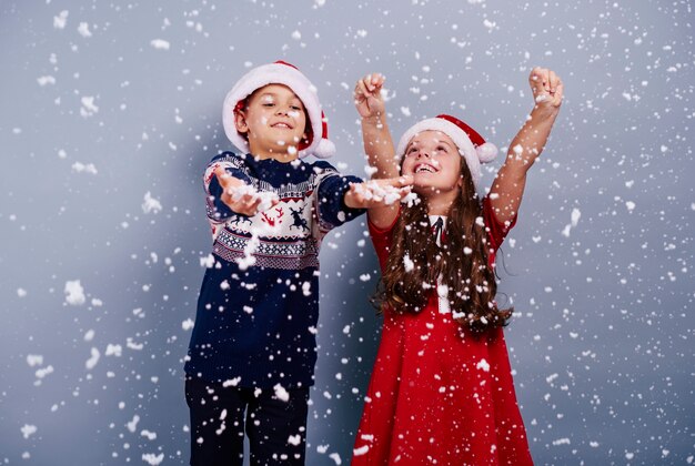 Happy children catching snowflake
