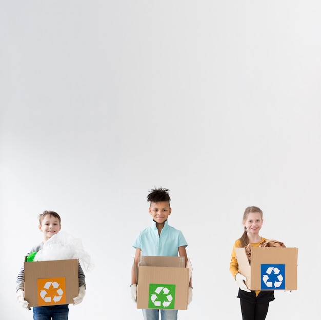 Happy children holding recycling boxes